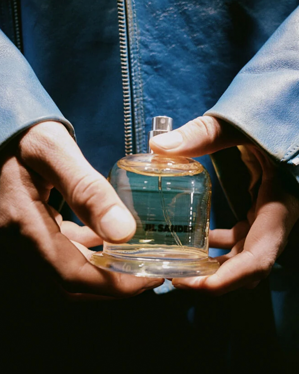 Jil Sander fragrance bottle held in hands