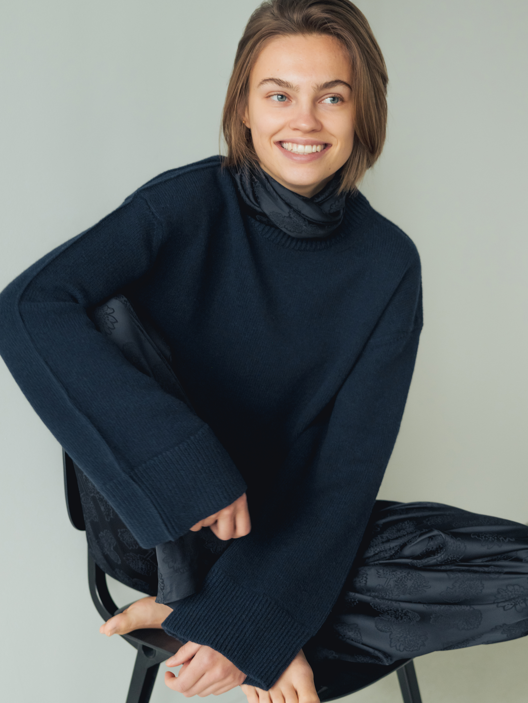 Model on chair wearing a Francon Editions Navy Sweater, photo by jeroen van de gruiter, 2025