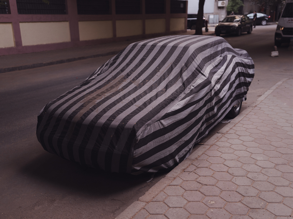 parked car with textile covering in cairo, photo by jeroen van de gruiter, 2025